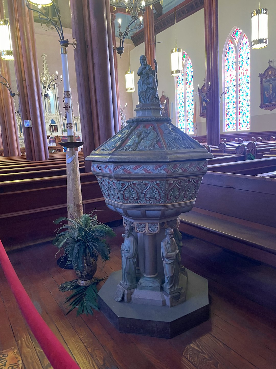 An ornate carved stone baptismal font inside a traditional church.
